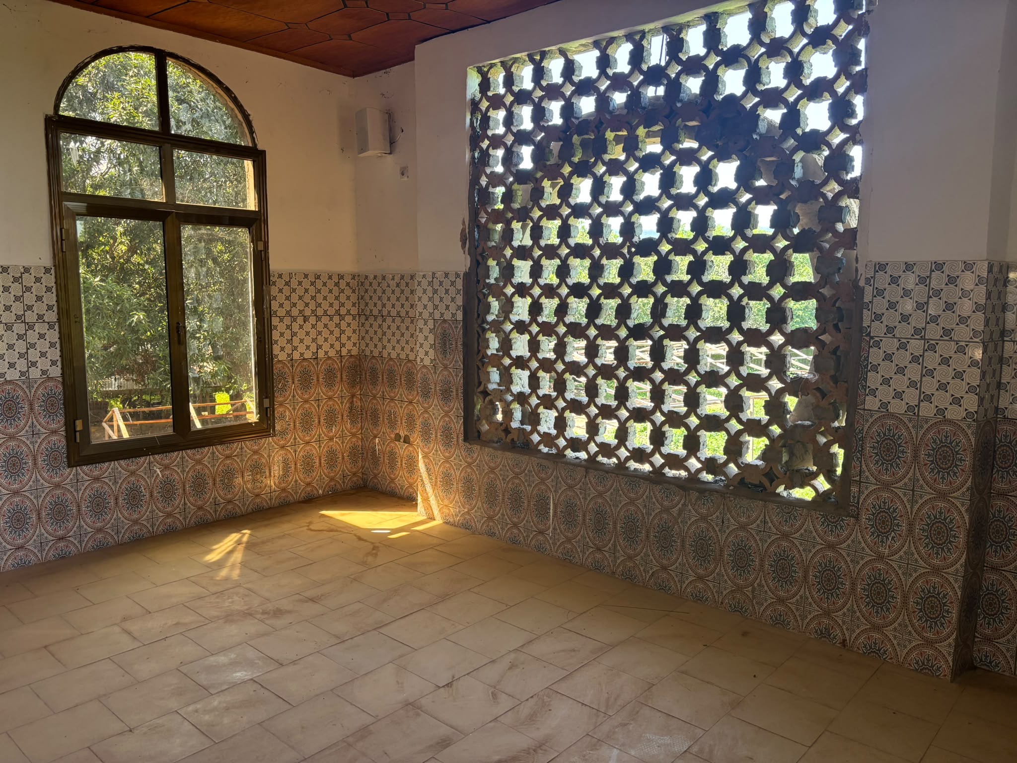 Lumière traversant le claustra hexagonal de la salle de prière